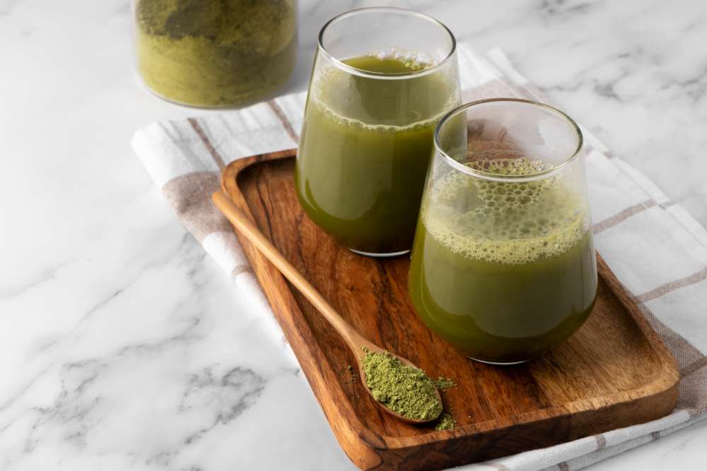 Skleničky s kratomovým čajem uvnitř na dřevěném prkénku 